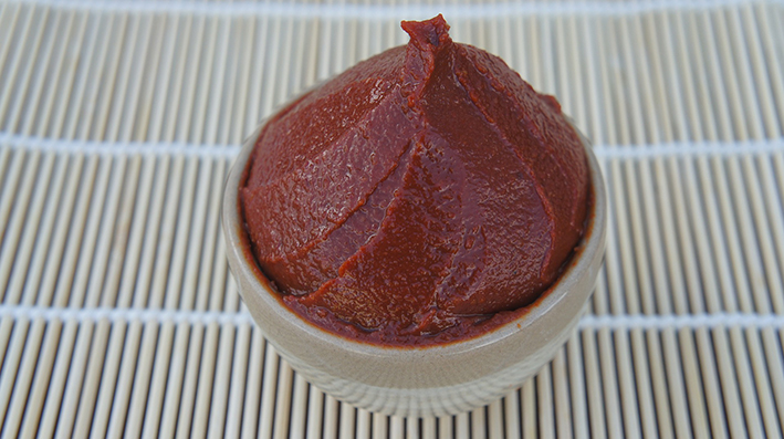 miso rojo en un bol de cerámica sobre esterilla de bambú