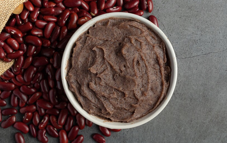 Paté a alubias pintas y azukis en un bol blanco sobre suelo gris