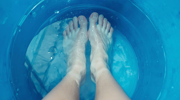 pies dentro de un recipiente de agua azul