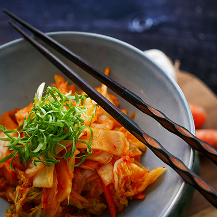 kimchi en vasija de barro con palillos
